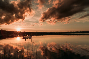 Fisher people on a lake at sunset