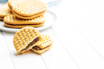 Sweet sandvich cookies. Biscuits with cocoa cream filling on white table.