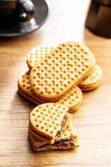 Sweet sandvich cookies. Biscuits with cocoa cream filling on kitchen table.