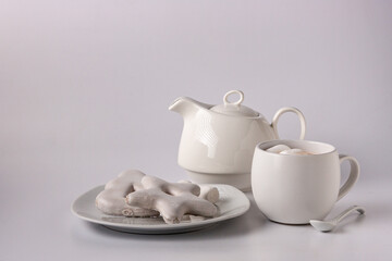 Fototapeta na wymiar gingerbread cookies in white glaze, white teapot, cocoa in a cup on a white background copy space