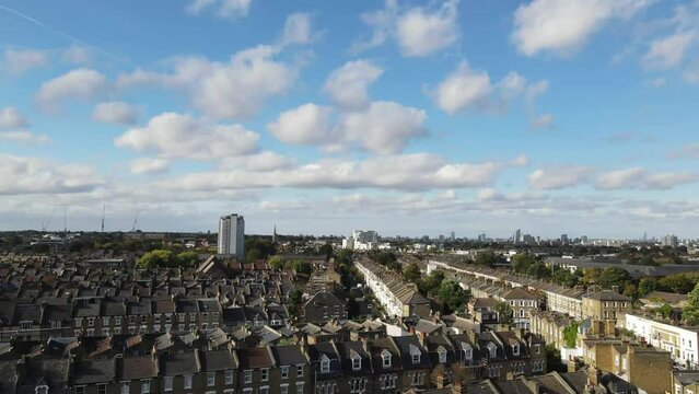 Dron shot UK england open shot sun afternoon sky buildings London smog mist dark church paning left covid trees tree front green bus back cars rush hour gray.mp4