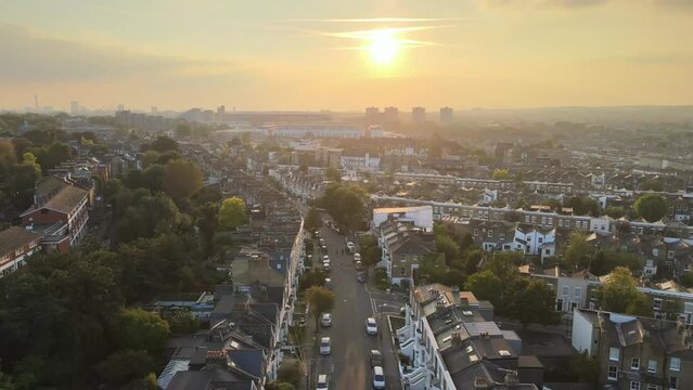Dron shot UK england open shot sun afternoon sky buildings London smog mist dark church paning left covid trees tree front green bus cars.mp4