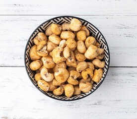 Canjica, hominy or white corn popcorn, sweet popcorn in a bowl over wooden table