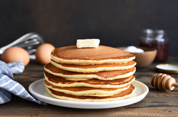 Blini or pancakes stack on wooden table with butter.  Maslenitsa holiday concept. Rustic style...