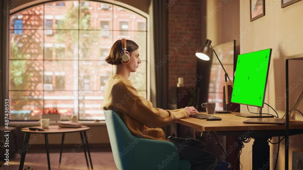 Fototapete young handsome man working from home on desktop computer with green screen mock up display. creative