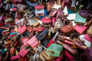 many small padlocks with names of couples hang as a symbol of love