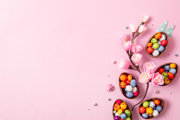 Chocolate easter eggs and decor flat lay for kids easter hunt egg concept on pink background. Sweets in the shape of an egg