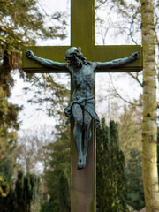 Fototapeta na wymiar Jesus am Kreuz Steinkreuz mit Patina im Park