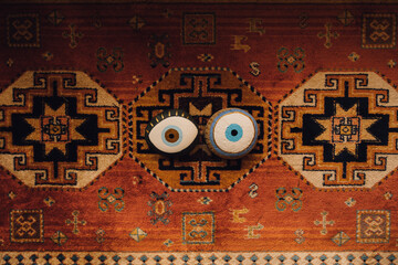 two painted evil eye rocks on patterned rug