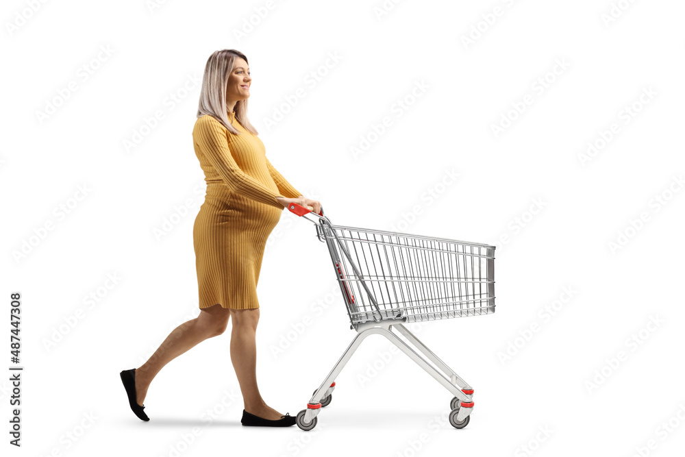 Sticker full length profile shot of a pregnant woman pushing an empty shopping cart