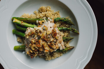 serving of Trout amandine with bulgur wheat and asparagus in white bowl