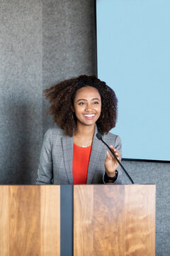 woman holding a a microphone while speaking