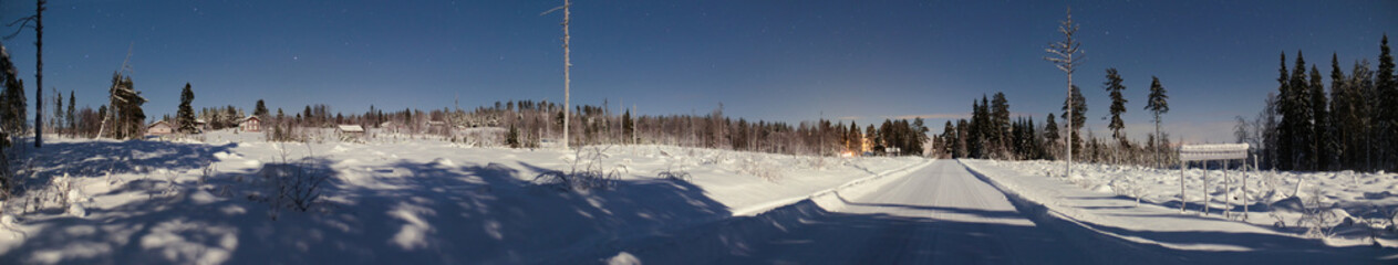 Fototapeta premium Night panorama of small Swedish town and road in winter, the town name Granbergsliden is written on the sign
