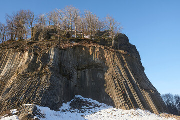 Fototapeta na wymiar Winter in the Lusatian mountains in the north of the Czech Republic. Basalt rock Zlaty vrch. Volcano rock formation Zlaty vrch built pentagonal and hexagonal basalt columns. 