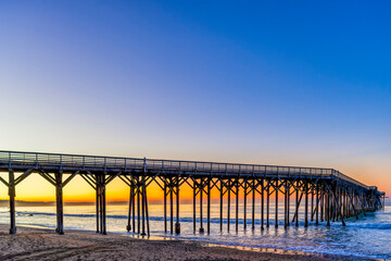 Pier, ocean, sand, beach at sunrise, sunset