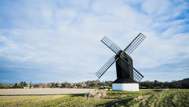 Timelapse of clods and sunshine with traditional windmill in English countryside