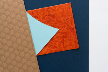 abstract paper design in cardboard, blue, orange, and white