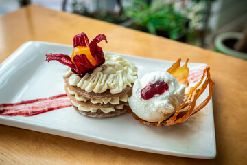 A stack of pancakes with cream and a scoop of ice cream. Gourmet dessert on a white rectangular plate