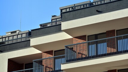 Fototapeta premium Abstract architecture, fragment of modern urban geometry,. Modern apartment building on a sunny day with a blue sky,. European residential apartment buildings.