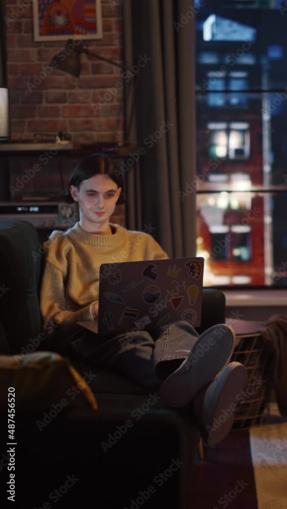 Poster vertical screen: young handsome man working from home on laptop computer in stylish loft apartment i
