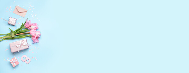 Gifts and beautiful tulip flowers on blue background with space for text. International Women's Day celebration