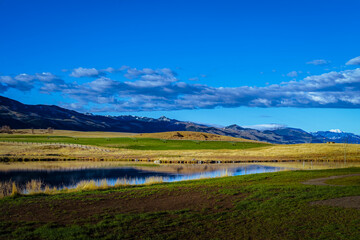 2022-02-14 GRASSLANDS AND MOUNTIN RANGE IN MONTANA WITH A BEAUTIFUL POND AND NICE OPEN BLUE SKYS WITH CLOUDS