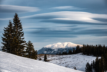 Fototapeta na wymiar Winterlandschaft mit schneebedecktem Berg und interessanter Wolkenformation