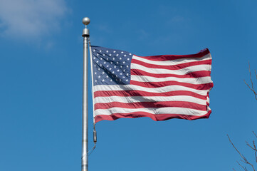 American flag against the blue sky in the wind