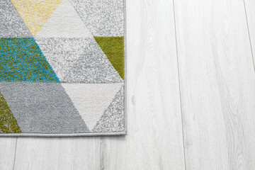 Fototapeta premium Soft carpet with abstract pattern on grey wooden floor