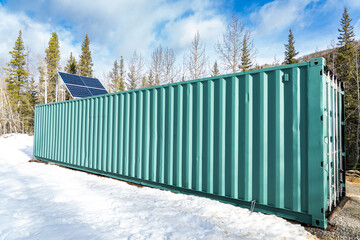 Solar panels mounted to the outside of a repurposed shipping container for remote power generation.