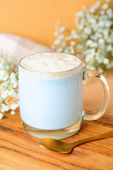 Glass cup of blue matcha latte and spoon on table