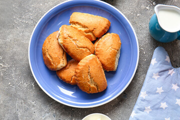 Plate of tasty sochniki with cottage cheese on grey background