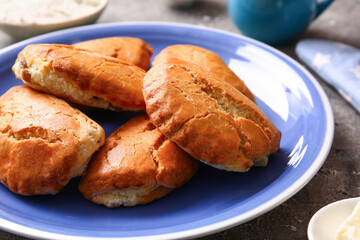 Plate of tasty sochniki with cottage cheese on grey background, closeup
