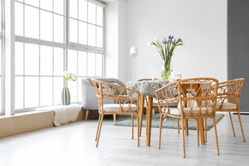 Vase with beautiful irises on dining table in room