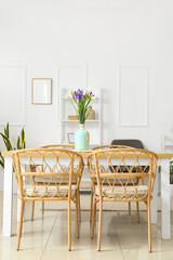 Vase with beautiful irises on dining table in room