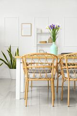Vase with beautiful irises on dining table in room