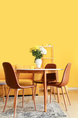 Vase with beautiful Chrysanthemum flowers on dining table in room