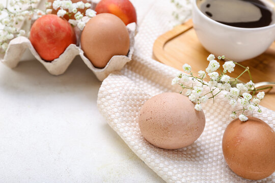 Chicken eggs and gypsophila flowers on light background, closeup