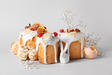 Delicious Easter cakes, gypsophila flowers and eggs on light background