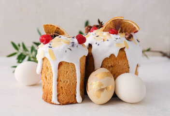 Delicious Easter cakes and eggs on light background