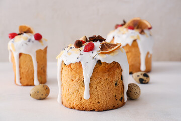 Delicious Easter cakes and eggs on light background