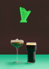 Neon sign of green harp above an Irish coffee with milk foam and pint of black stout craft beer Minimal pub concept. Plum background.