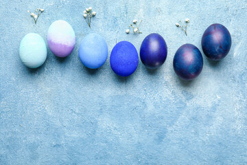 Composition with painted Easter eggs and gypsophila flowers on color background