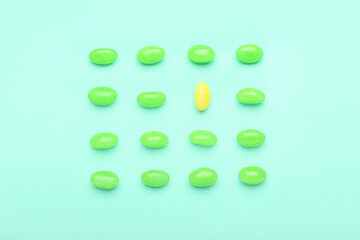 Different jelly beans on color background. Concept of uniqueness