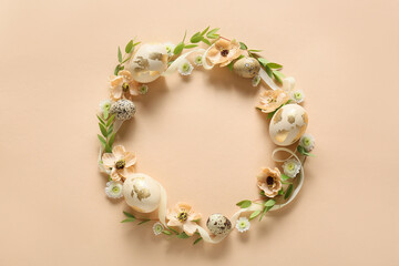Beautiful wreath with Easter eggs and flowers on beige background
