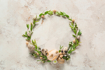 Fototapeta na wymiar Beautiful wreath with Easter eggs and green branches on light background