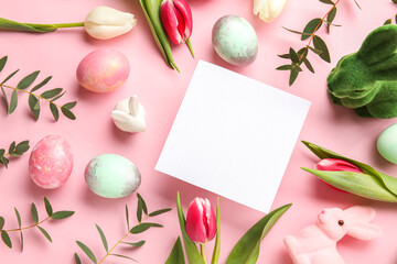 Composition with blank card, flowers and Easter eggs on pink background