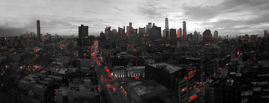 Red lights of the New York City skyline shining against a black and white cityscape in Manhattan NYC