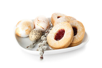 Plate with delicious cookies for Easter with eggs and willow branches on white background
