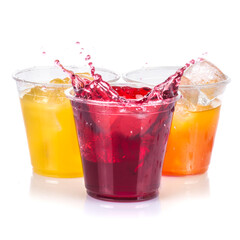 Clear plastic cups with red yellow and orange juice drinks splashing from ice cube on white background